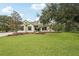 Charming two-story home featuring a lush green lawn and mature trees against a clear blue sky at 3906 Twin Rivers Trl, Parrish, FL 34219