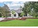 Charming exterior view of a landscaped lawn, accented with shade trees, and a welcoming front porch at 3906 Twin Rivers Trl, Parrish, FL 34219