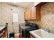 Functional laundry room featuring washer, dryer, storage cabinets, and stylish wallpaper at 3906 Twin Rivers Trl, Parrish, FL 34219