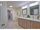 Modern bathroom featuring double sinks, quartz counters, and views to the laundry area at 4140 Central Sarasota Pkwy # 1235, Sarasota, FL 34238