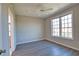 Cozy bedroom with a ceiling fan, large window offering natural light, and sleek gray wood-look flooring at 4140 Central Sarasota Pkwy # 1235, Sarasota, FL 34238