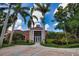 Inviting clubhouse featuring a grand entrance framed by palm trees and a spacious parking area at 4140 Central Sarasota Pkwy # 1235, Sarasota, FL 34238