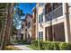 Attractive condo building with lush landscaping, screened lanais, and charming architectural details under a sunny sky at 4140 Central Sarasota Pkwy # 1235, Sarasota, FL 34238