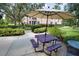 Outdoor picnic area with a purple table, benches, and umbrella for shaded gatherings at 4140 Central Sarasota Pkwy # 1235, Sarasota, FL 34238