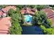Resort-style pool with palm trees, set amidst beautiful landscaping and red-tiled roof buildings at 4140 Central Sarasota Pkwy # 1235, Sarasota, FL 34238