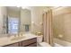 A relaxing bathroom features a tub with shower, a vanity, and a mirror at 4267 Expedition Way, Osprey, FL 34229