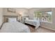 This well-lit bedroom has twin beds, neutral walls, and large window with a view at 4267 Expedition Way, Osprey, FL 34229