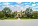Stunning building exterior with lush landscaping, red tile roof, and swaying palm trees at 4267 Expedition Way, Osprey, FL 34229