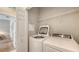Well-equipped laundry room with modern washer and dryer and storage shelving at 4267 Expedition Way, Osprey, FL 34229