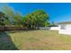 Large backyard with a mix of green grass, mature trees and privacy fencing at 4505 18Th W Ave, Bradenton, FL 34209