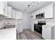 Modern kitchen with stainless steel appliances, white cabinets, and sleek countertops with modern lighting at 4505 18Th W Ave, Bradenton, FL 34209