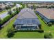 Aerial view of a home featuring a screened-in pool, set in a lush neighborhood with manicured lawns at 4704 Sarca Ct, Lakewood Ranch, FL 34211