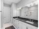 Bathroom with double vanity, white cabinets, dark countertop, and a separate glass-enclosed shower at 4704 Sarca Ct, Lakewood Ranch, FL 34211