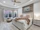 This primary bedroom boasts a tray ceiling, wood accent wall, and bay windows for a relaxing, bright space at 4704 Sarca Ct, Lakewood Ranch, FL 34211