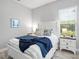 Cozy bedroom with bright window view, white furniture and blue decorative accents at 4704 Sarca Ct, Lakewood Ranch, FL 34211
