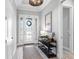 Light and airy entryway with decoratively framed door, furniture piece and wood-look tile at 4704 Sarca Ct, Lakewood Ranch, FL 34211