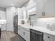 Bright kitchen featuring white cabinets, tile backsplash, modern faucet, stainless steel appliances and wood-look tile floors at 4704 Sarca Ct, Lakewood Ranch, FL 34211
