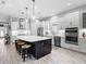 Spacious kitchen with large island, stainless steel appliances, designer lighting, modern cabinetry and wood-look tile floors at 4704 Sarca Ct, Lakewood Ranch, FL 34211