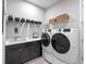 Laundry room with front-load washer and dryer, shelving, and a utility sink at 4704 Sarca Ct, Lakewood Ranch, FL 34211