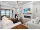 Cozy living room with an electric fireplace, shiplap accent wall and sliding glass doors at 4704 Sarca Ct, Lakewood Ranch, FL 34211