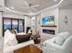Elegant living room with a modern fireplace, shiplap accent wall, and views of the serene outdoor space at 4704 Sarca Ct, Lakewood Ranch, FL 34211