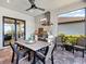Outdoor kitchen with grill and dining table under a covered patio at 4704 Sarca Ct, Lakewood Ranch, FL 34211