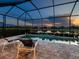 Relaxing screened-in pool area with comfortable lounge chairs and scenic views of the lake and neighborhood at 4704 Sarca Ct, Lakewood Ranch, FL 34211