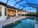 A screened-in pool with outdoor lounge seating, perfect for evening relaxation by the tranquil water at 4704 Sarca Ct, Lakewood Ranch, FL 34211