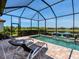 Inviting screened-in pool area with comfortable lounge chairs and serene lake views, perfect for relaxation and leisure at 4704 Sarca Ct, Lakewood Ranch, FL 34211