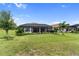 Green backyard with lush landscaping and mature trees behind the screened-in lanai at 4735 Cassio Ct, Bradenton, FL 34211