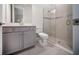 Bathroom with gray cabinets, shower with glass door, and neutral tile at 4735 Cassio Ct, Bradenton, FL 34211
