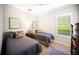 Guest bedroom featuring two twin beds, shuttered windows, and neutral decor at 4735 Cassio Ct, Bradenton, FL 34211