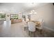 Bright dining area with a chandelier and an open floor plan leading to the living room and outdoor view at 4735 Cassio Ct, Bradenton, FL 34211