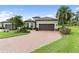 Beautiful home features a paver driveway, tile roof, two-car garage, and tropical landscaping at 4735 Cassio Ct, Bradenton, FL 34211