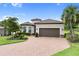 Attractive single-story home with mature trees, a paver driveway, and a tile roof at 4735 Cassio Ct, Bradenton, FL 34211