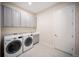 Bright laundry room with gray cabinets and front-loading washer and dryer at 4735 Cassio Ct, Bradenton, FL 34211