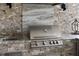 Outdoor kitchen featuring a stainless steel grill, granite countertop, and a sink at 4735 Cassio Ct, Bradenton, FL 34211