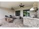 A covered patio features comfortable seating, ceiling fans, and a built-in kitchen with a stone-accented bar for outdoor entertaining at 4735 Cassio Ct, Bradenton, FL 34211
