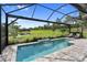This is a screened-in pool area with a scenic view of a lush green backyard and a serene pond, offering a tranquil retreat at 4735 Cassio Ct, Bradenton, FL 34211