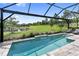 Relax in the screened pool area with a stunning view of the lake and well-manicured yard at 4735 Cassio Ct, Bradenton, FL 34211