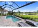 This screened-in pool offers a serene escape with a view of the lake, palm trees, and comfortable lounge chairs by the poolside at 4735 Cassio Ct, Bradenton, FL 34211