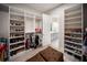 Well-organized walk-in closet with built-in shelving, hanging racks, and a comfortable ottoman at 4735 Cassio Ct, Bradenton, FL 34211