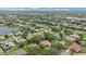 Expansive aerial view of a residential community with mature trees, lakes, and well-maintained homes under a blue sky at 5619 Oak Grove Ct, Sarasota, FL 34233