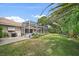 Spacious backyard with a screened-in pool, patio, and lush landscaping at 5619 Oak Grove Ct, Sarasota, FL 34233