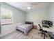 Bedroom features ceiling fan, large window with blinds, and light-colored walls at 5619 Oak Grove Ct, Sarasota, FL 34233