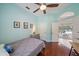 Inviting bedroom with hardwood floors, a ceiling fan, and French doors leading to the outdoor living space at 5619 Oak Grove Ct, Sarasota, FL 34233
