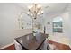 Open-concept dining area with modern chandelier lighting fixtures, hardwood floors, and access to the kitchen at 5619 Oak Grove Ct, Sarasota, FL 34233