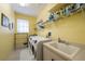 Functional laundry room with modern washer/dryer, ample shelving, and a convenient utility sink at 5619 Oak Grove Ct, Sarasota, FL 34233