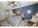 Comfortable main bedroom featuring a wooden bed frame, ceiling fan, and calming blue accents at 5619 Oak Grove Ct, Sarasota, FL 34233
