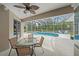 Covered patio with dining set, overlooking a screened pool area at 5619 Oak Grove Ct, Sarasota, FL 34233